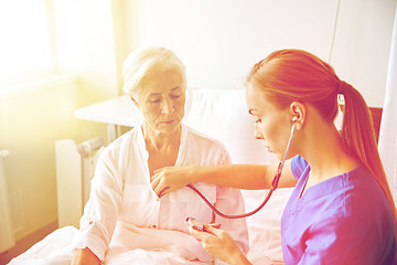 Image showing nurse with stethoscope and senior woman at clinic