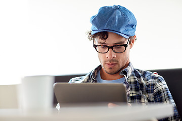 Image showing man with tablet pc sitting at cafe table