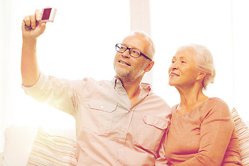 Image showing happy senior couple with camera at home