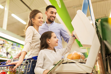 Image showing family weighing oranges on scale at grocery store