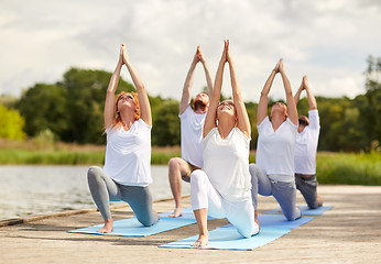 Image showing group of people making yoga exercises outdoors