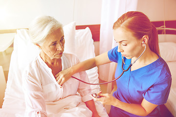 Image showing nurse with stethoscope and senior woman at clinic