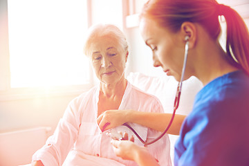 Image showing nurse with stethoscope and senior woman at clinic