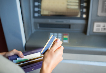 Image showing hands with money and credit card at atm machine