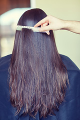 Image showing hand with comb combing woman hair at salon