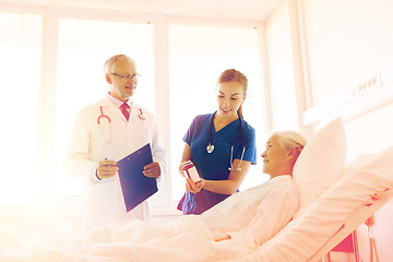 Image showing doctor giving medicine to senior woman at hospital