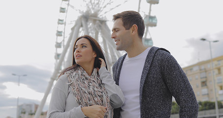 Image showing Young couple standing in front of a ferris wheel