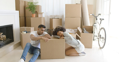 Image showing Tired young couple relaxing on cardboard boxes