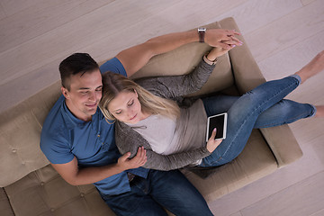 Image showing youg couple in living room with tablet top view