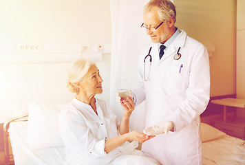 Image showing doctor giving medicine to senior woman at hospital