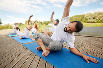 Image showing group of people making yoga exercises outdoors