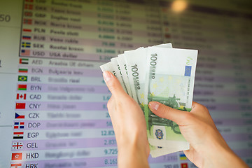 Image showing hands with euro money over currency exchange rates