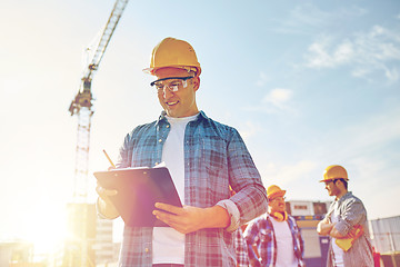 Image showing builder in hardhat with clipboard at construction