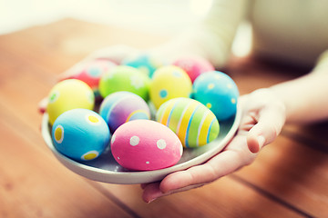 Image showing close up of woman hands with colored easter eggs