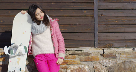 Image showing Happy mixed race girl standing with snowboard