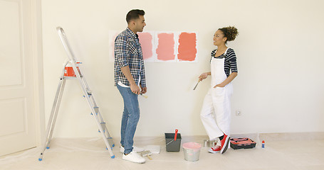 Image showing Young couple trying to decide on a paint color