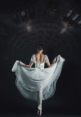 Image showing Portrait of the classical ballerina in white dress on black back