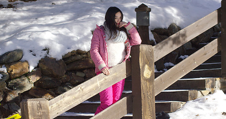 Image showing Adorable asian girl standing on wooden stairs