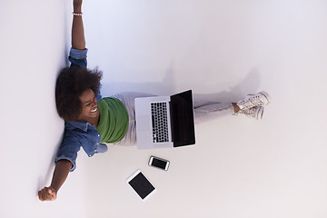 Image showing african american woman sitting on floor with laptop top view