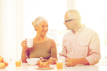 Image showing happy senior couple having breakfast at home