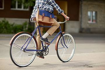 Image showing young hipster man with bag riding fixed gear bike