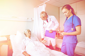 Image showing doctor and nurse visiting senior woman at hospital