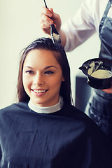 Image showing happy woman with stylist coloring hair at salon