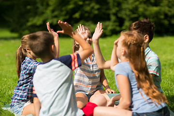 Image showing group of happy kids making high five outdoors