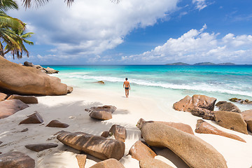 Image showing Man enjoying Anse Patates picture perfect beach on La Digue Island, Seychelles.