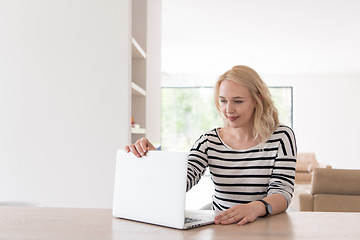 Image showing Young woman with laptop at home