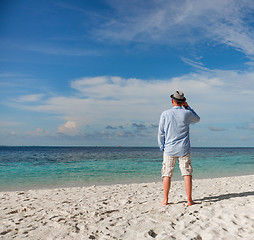 Image showing Man walking along a tropical beach in the Maldives.