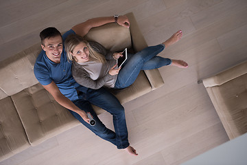 Image showing youg couple in living room with tablet top view