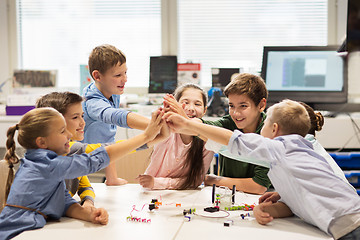 Image showing happy children making high five at robotics school