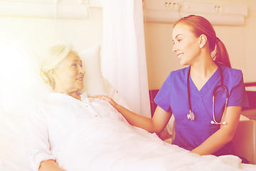 Image showing doctor or nurse visiting senior woman at hospital