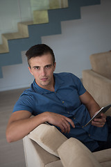 Image showing young man using a tablet at home