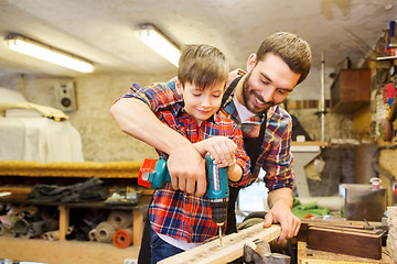 Image showing father and son with drill working at workshop