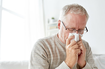 Image showing sick senior man with paper wipe blowing his nose