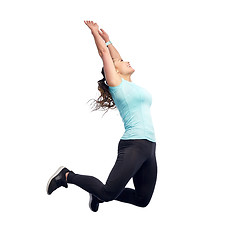 Image showing happy smiling sporty young woman jumping in air