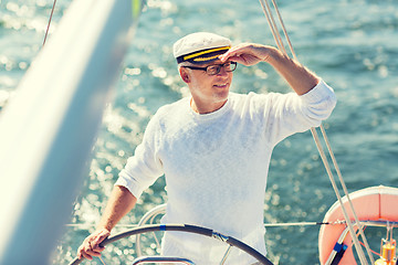 Image showing senior man at helm on boat or yacht sailing in sea