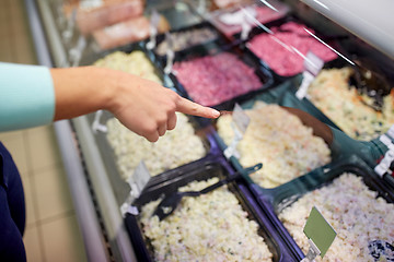 Image showing customer hand pointing at salads on grocery stall