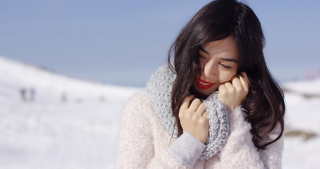 Image showing Young woman on ski slope with cozy sweater