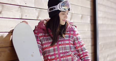 Image showing Smiling woman in pink snowsuit with board