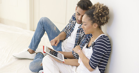 Image showing Handsome black couple sits and uses tablet