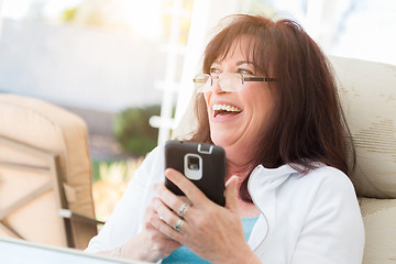 Image showing Attractive Middle Aged Woman Laughing While Using Her Smart Phon