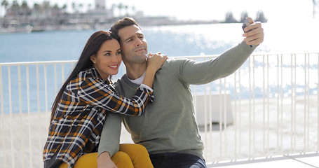 Image showing Young couple taking a selfie at the seaside