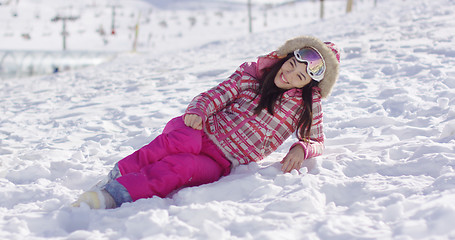 Image showing Young woman in pink snowsuit with ski goggles