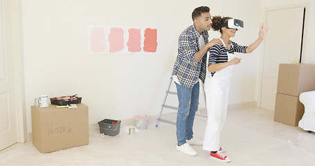 Image showing Handsome husband helps his wife wearing overalls