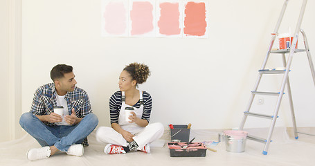 Image showing Young couple enjoying coffee while renovating