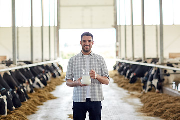 Image showing man or farmer with jug of cows milk on dairy farm