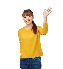 Image showing happy asian young woman waving hand over white